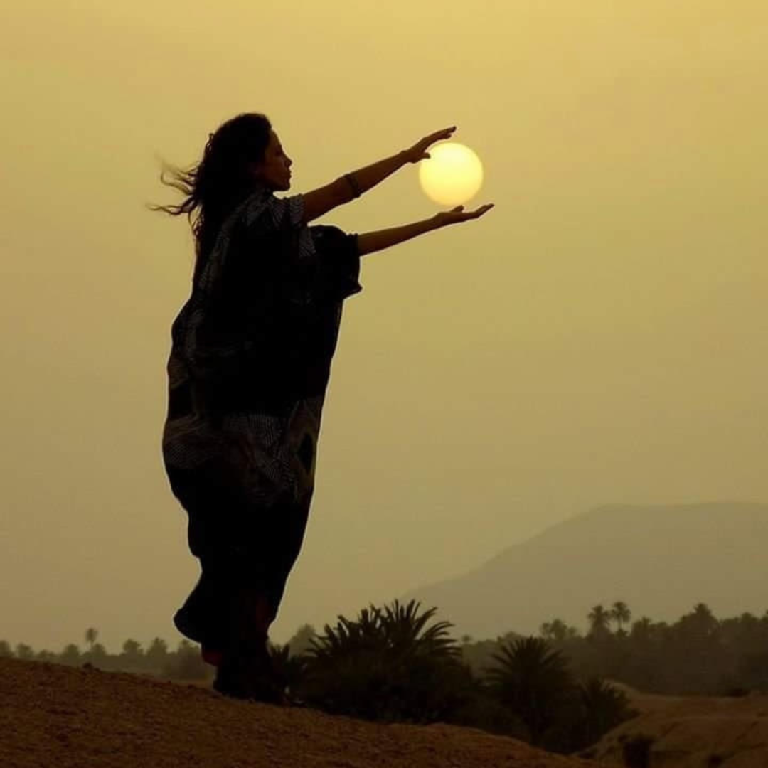 Nathalie, astrologue, dans le desert faisant face au soleil