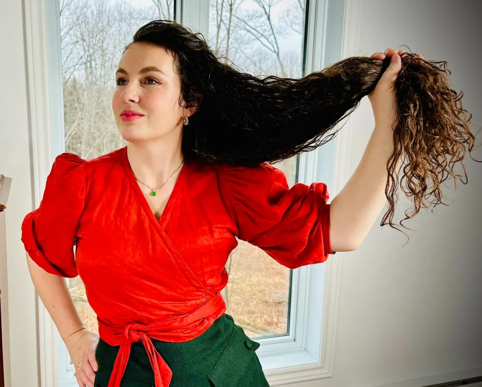 Photo de Katherine tenant ses longs cheveux dans une main